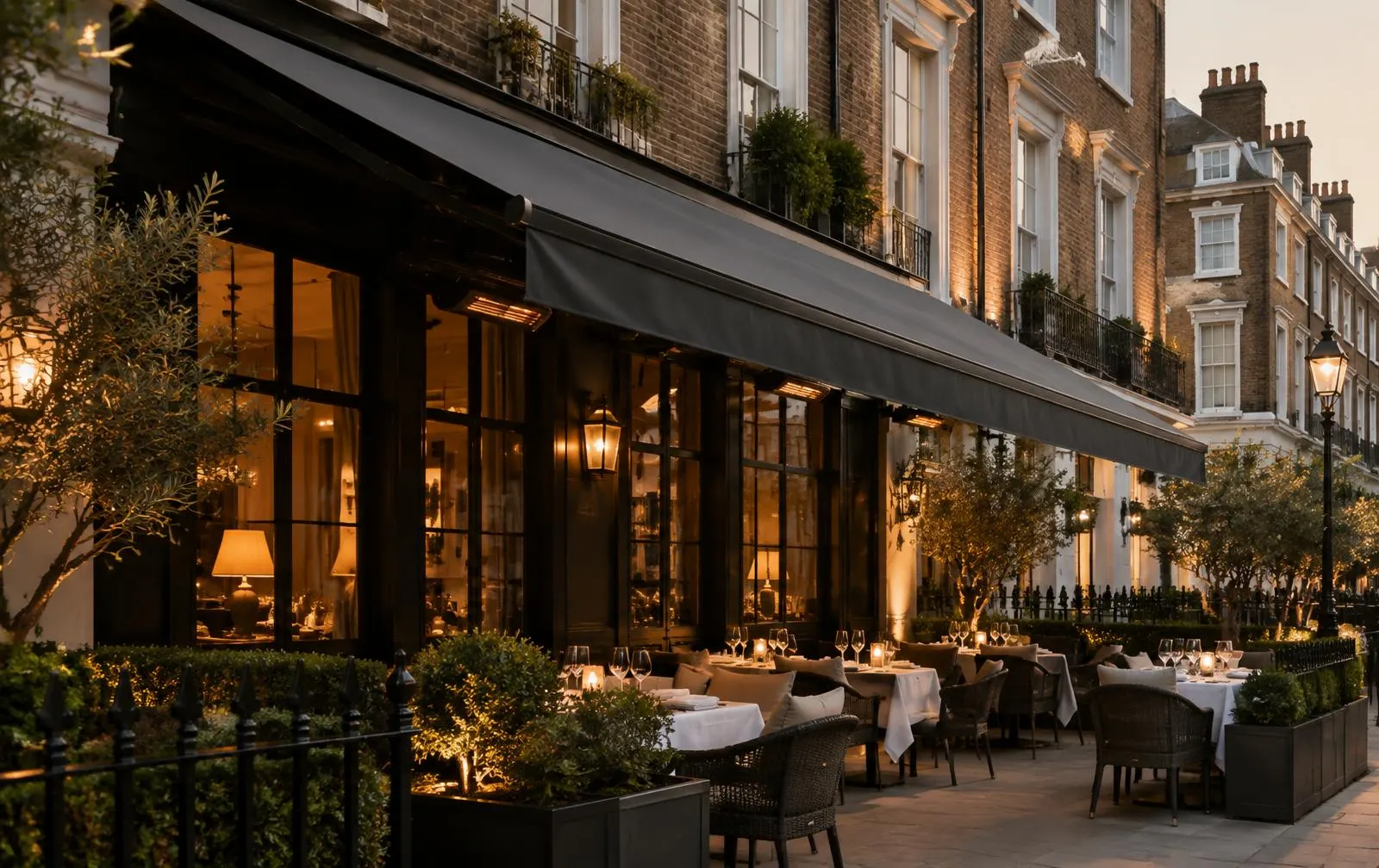 London restaurant terrace under a charcoal commercial awning at dusk